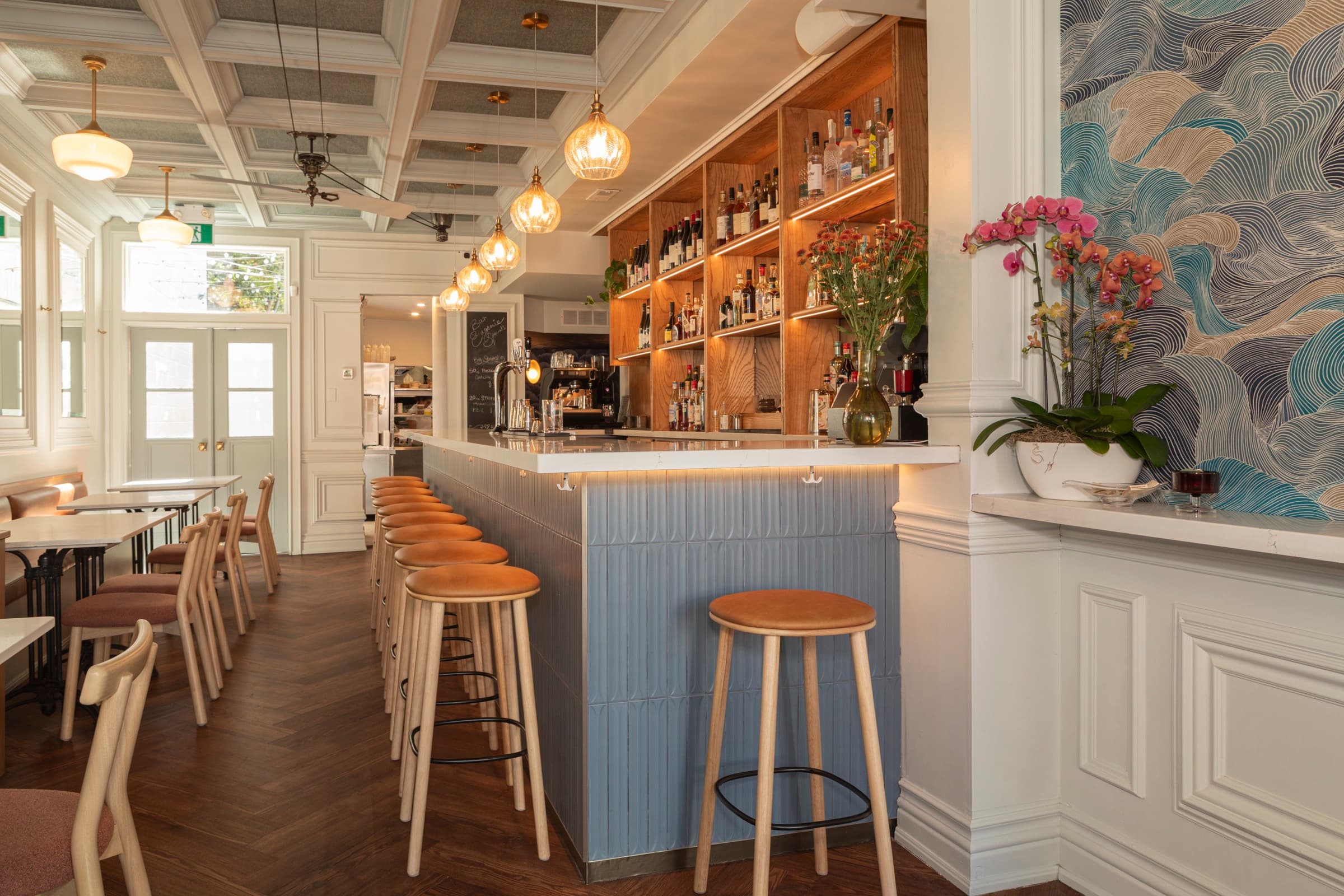 Bar Eugenie — blue tile bar front with oak back-bar and pendant lights